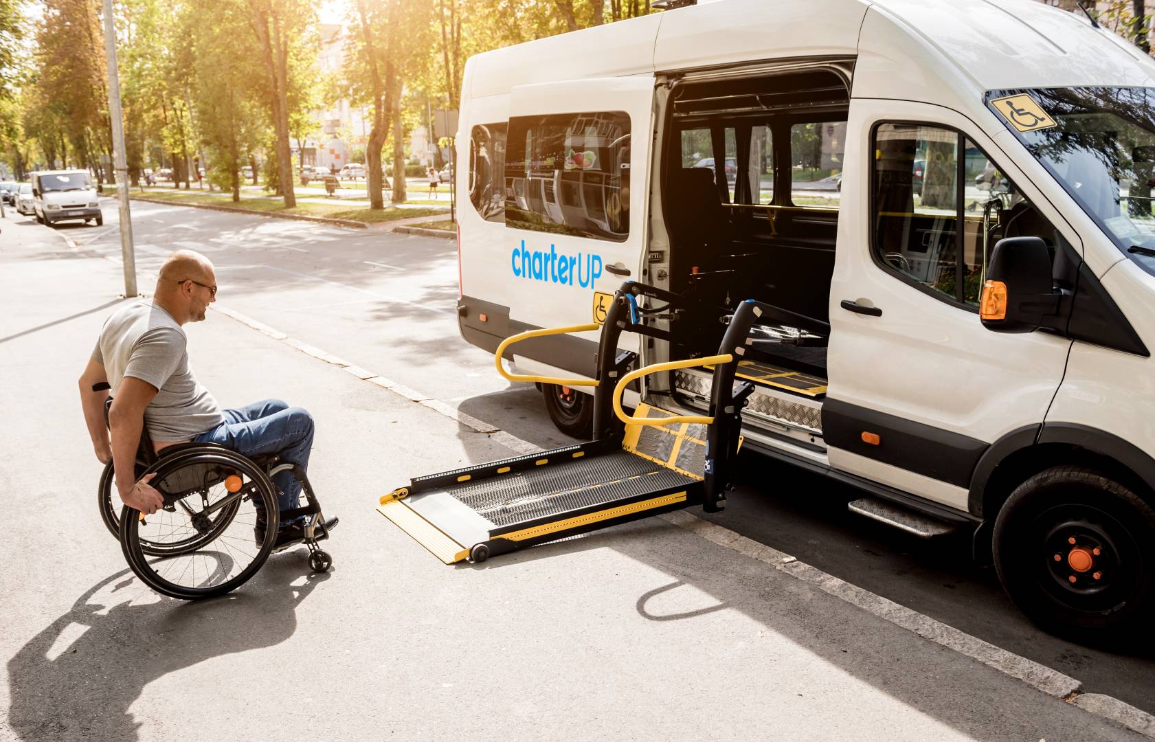 A man in a wheelchair moves to the lift of a specialized vehicle